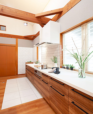 白い天板とナチュラルな木目調パネルのキッチン
